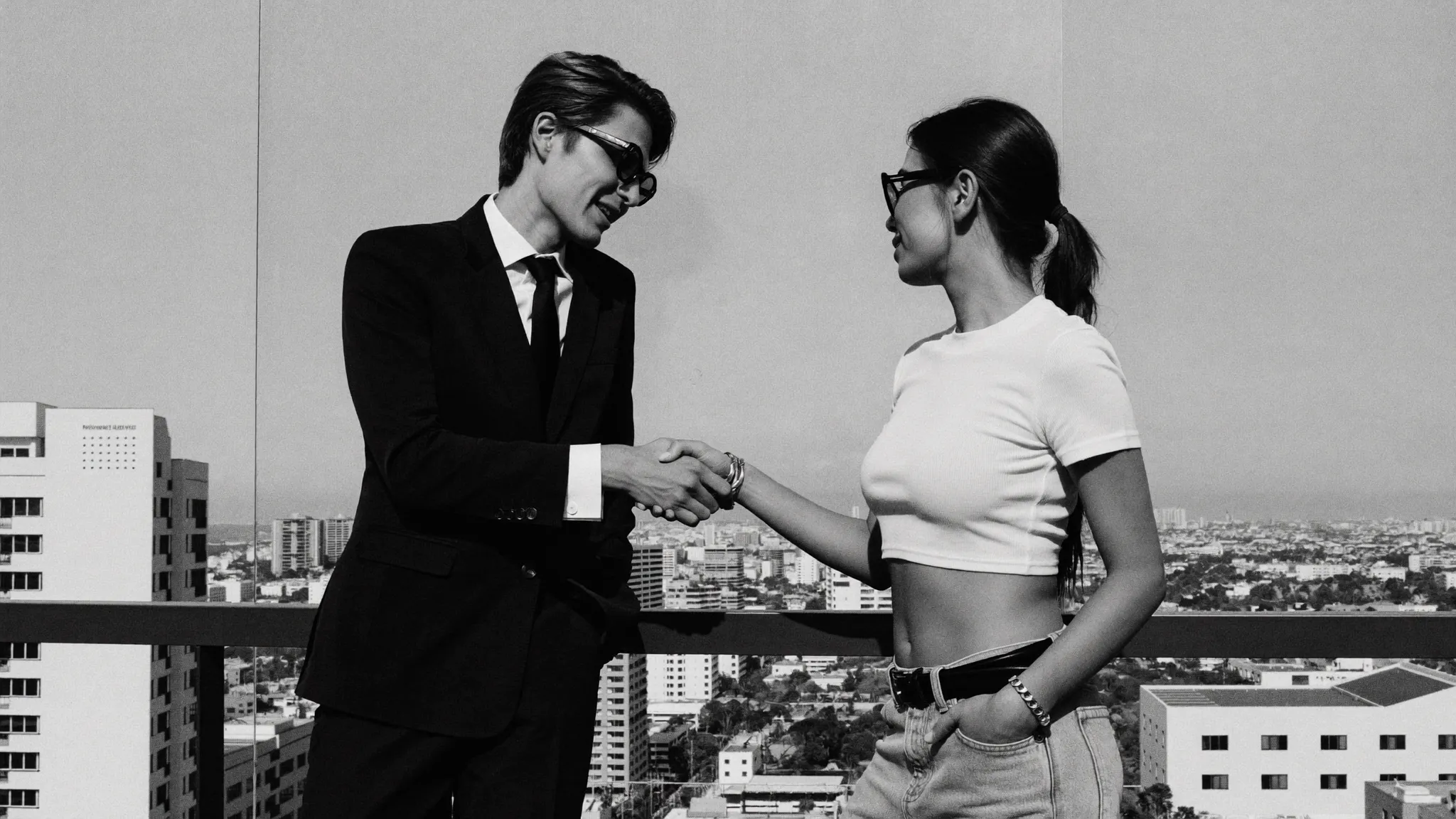 Two creatives shaking hands over the Miami skyline, in black and white
